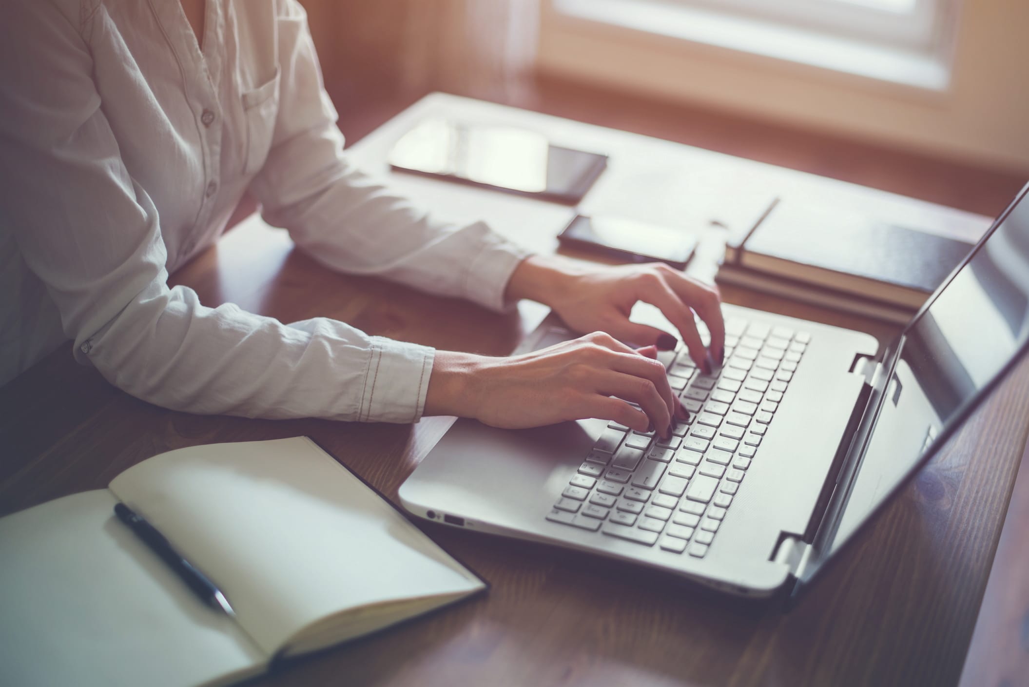 A woman is working on a portable computer